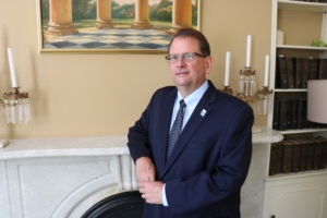 Mark Hudson Executive Director leaning on mantel in parlor at Dower House