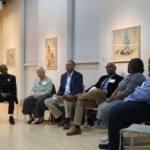Descendants sitting in a semi-circle with Fred Murphy, facilitator, sitting in middle at gallery space at Georgetown University.