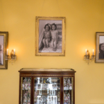 3 Portraits hanging on a yellow painged wall