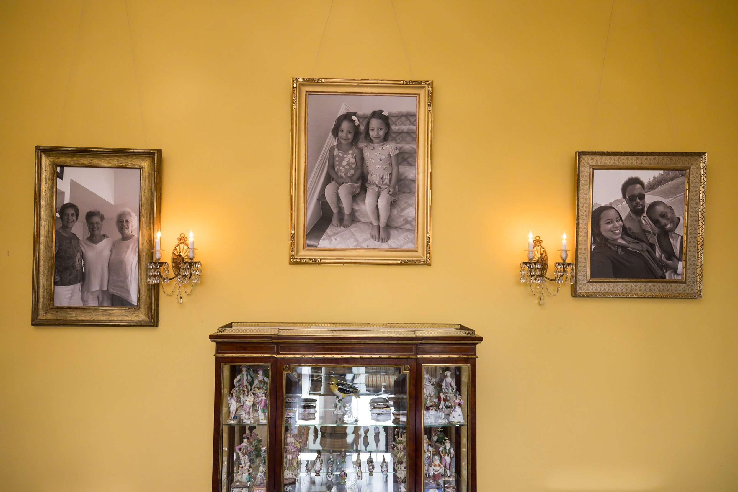 3 Portraits hanging on a yellow painged wall