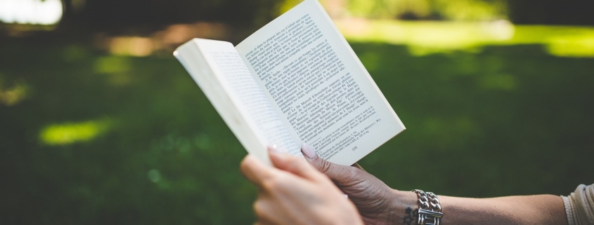 woman's hands holding book