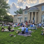 Multitude of people sitting on picnic blankets