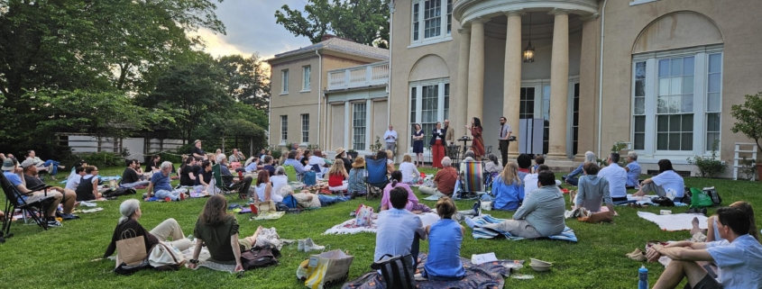 Multitude of people sitting on picnic blankets