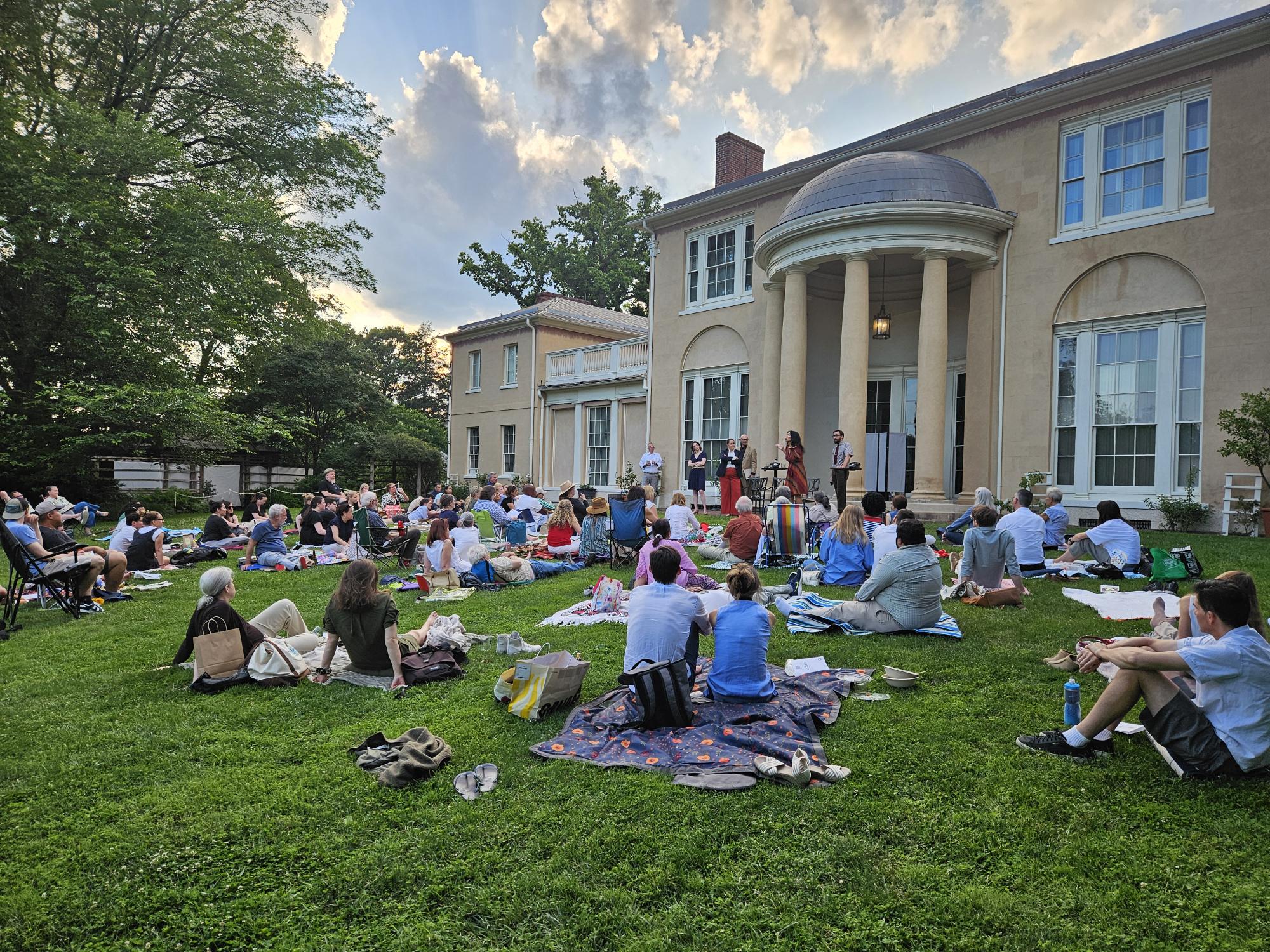 Multitude of people sitting on picnic blankets